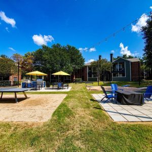 Outdoor lounge area with grilling station and ping-pong